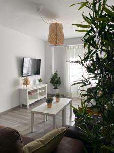 a living room with a white table and a tv at Apartamento Corazón de Cazorla by Clabao in Cazorla +11 photos