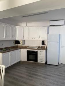 La cuisine est équipée de placards blancs et d'un réfrigérateur blanc. dans l'établissement Apartamento Corazón de Cazorla by CLABAO, à Cazorla