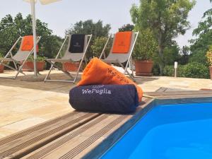 a pillow sitting on the edge of a swimming pool at WePuglia - Canto dei Grilli in Noci