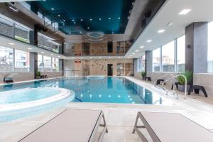 a large pool in a building with a large swimming pool at Resort Apartamenty Klifowa Rewal 10 in Rewal