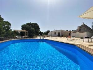 a blue swimming pool in front of a house at WePuglia - Canto dei Grilli in Noci
