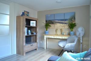 een woonkamer met een bureau en een stoel bij Zomerhuis "aan de kust" in Egmond aan Zee