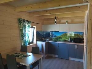 a kitchen with a table and a dining room at Słoneczny Domek in Kluszkowce