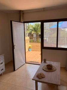 um quarto com uma mesa e uma porta de vidro deslizante em Casa Camar em Corralejo