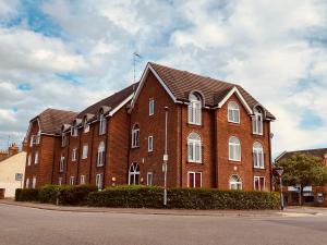 ein großes rotes Backsteingebäude mit einer Flagge darauf in der Unterkunft Eskdaill Place Apartment in Kettering