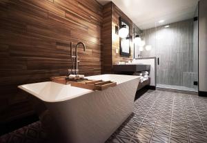 a bathroom with a large white tub and wooden walls at Hotel Vandivort in Springfield