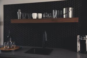 a counter with glasses and wine glasses on a wall at Hotel Vandivort in Springfield