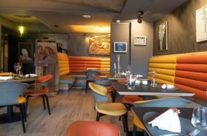 un ristorante con tavoli e sedie in una stanza di Locanda degli Artisti Art Hotel a Canazei