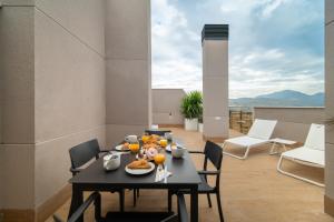 Ahoy Apartments في إل كامبيلو: طاولة سوداء مع طعام عليها شرفة