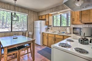 a kitchen with a white refrigerator and a table at Cozy Cabin by Colorado River Hike, Bike, Ski in Greer