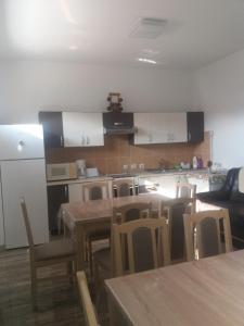 a kitchen with a table and chairs and a kitchen with white cabinets at VILA GE in Sebeş