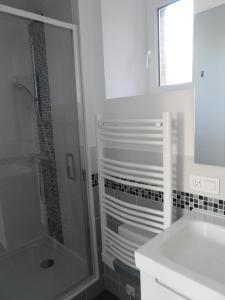 a white bathroom with a shower and a sink at A L'Oree Du Lin in Mentheville