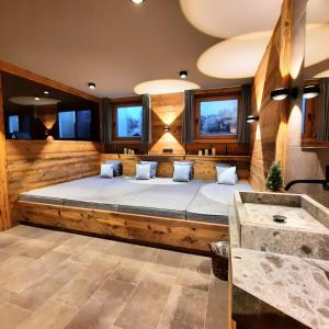 una camera con un grande letto in una stanza con finestre di HAHNENKAMM SUITE Ski-in Ski-out direkt an der Hahnenkammbahn a Kitzbühel