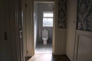 a bathroom with a toilet and a window at Sunrise Cottage on shores off Lough Gowna in Scrabby +12 photos