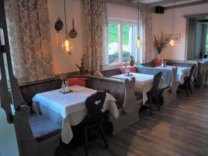 a restaurant with four tables and chairs and a window at Pension Margarete in Zell am See