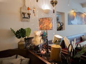 een woonkamer met een tafel met een lamp en planten bij Hotel Zum Vetter in Finsterwalde