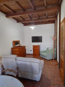 ein Wohnzimmer mit einem Sofa und einem TV in der Unterkunft Casa Sigiu - La Terrazza in Rieti