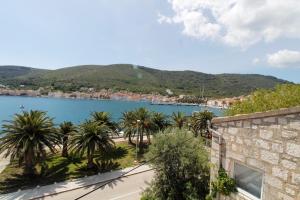 a view of a body of water with palm trees at Apartment Karlo Vis in Vis