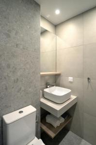 a bathroom with a white toilet and a sink at Sea-duction Studios in Nea Iraklia