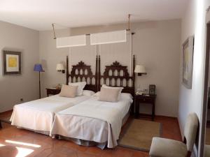 a bedroom with a large bed with white sheets at Parador de Cuenca in Cuenca
