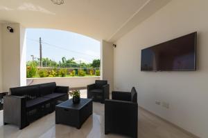 a living room with black furniture and a large window at IL GIARDINO in Procida