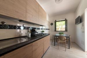 a kitchen with wooden cabinets and a table and a window at IL GIARDINO in Procida