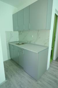 una cocina con armarios blancos y encimeras de mármol en Bovan GREEN LAKE apartments en Soko Banja