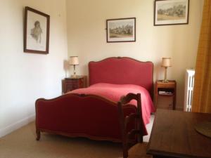 1 dormitorio con 1 cama roja y 2 mesas en Château du Prada, en Labastide-dʼArmagnac