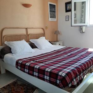 Un dormitorio con una cama con una manta a cuadros. en Ostréane-en-Ré, en Rivedoux-Plage