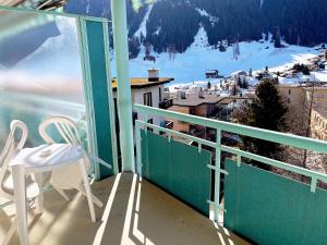 a balcony with two chairs and a view of a mountain at Bernina Bed and Breakfast in Davos