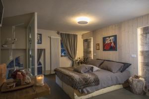 1 dormitorio con 1 cama grande y espejo en L'angolino di Bonny, en Arvier