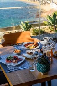 a wooden table with plates of food on it at Panormos Village Hotel in Mykonos