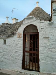 ein weißes Gebäude mit einer Tür und einem Dach in der Unterkunft Trullo Monte Santo 50 in Alberobello