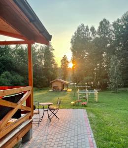 patio con mesa, sillas y parque infantil en Zarasaičio ežero sodyba, en Magučiai
