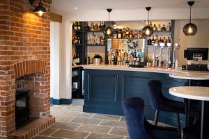 a bar in a restaurant with a brick wall at The Three Lions in Fordingbridge