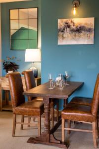 a dining room with a wooden table and chairs at The Three Lions in Fordingbridge