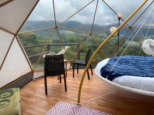 a room with a tent with a table and chairs at Alua Glamping in Pereira