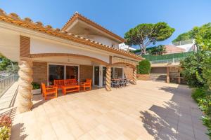 eine Terrasse eines Hauses mit orangefarbenen Stühlen in der Unterkunft Villa Eugenia in L'Escala