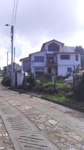 an empty street in front of a white house at Hospedaje Guatavita vereda Montecillo casa S.ines in Guatavita