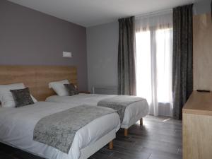 Châtillon-de-MichailleにあるHotel Marinetのベッド2台と窓が備わるホテルルームです。