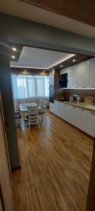 Black Sea View - Luxory apartment by the sea في مدينة بورغاس: مطبخ وغرفة طعام مع طاولة وكراسي