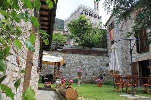 patio z parasolem i budynkiem w obiekcie Residenza Le Logge w mieście Gubbio +18 zdjęć