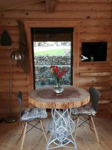 un tavolo in una stanza con un vaso di fiori sopra di Ravenglass Log Cabin a Ravenglass