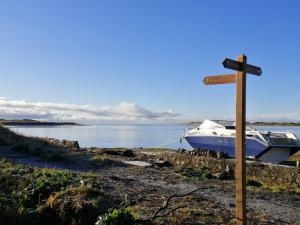 a wooden cross with a boat on the shore at Ravenglass Log Cabin in Ravenglass