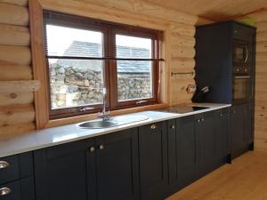 a kitchen with a sink and a window at Ravenglass Log Cabin in Ravenglass