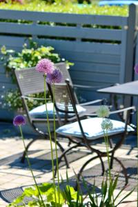 einen Stuhl neben einem Tisch und lila Blumen in der Unterkunft Kleines Landleben in Hohwacht