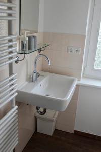 a white sink in a bathroom with a window at Kleines Landleben in Hohwacht
