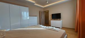 a bedroom with a bed and a flat screen tv at Black Sea View - Luxory apartment by the sea in Burgas City