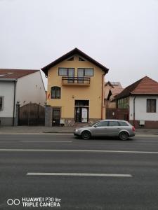 a car parked on the street in front of a house at Casa Tătar in Braşov