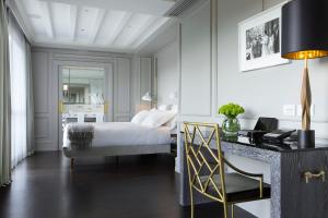 a bedroom with a bed and a desk with a chair at Portrait Firenze - Lungarno Collection in Florence